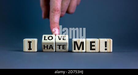 Hand dreht Würfel und ändert den Ausdruck "Ich hasse mich" in "Ich liebe mich". Schöner grauer Hintergrund. Psychologisches Konzept. Speicherplatz kopieren. Stockfoto
