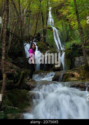 Junge Frau mit einem kleinen Wasserfall in Andoin Stockfoto