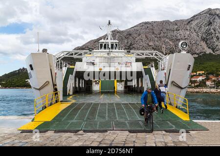 Passagiere steigen an Bord der Fähre nach Korcula Altstadt, als ein Radfahrer in Orebic, Kroatien im Oktober 2017 ablegt. Stockfoto