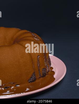 Vertikale Aufnahme eines leckeren Schokoladenkuchen in einem gebacken bundt Pfanne und in Ganache bedeckt Stockfoto