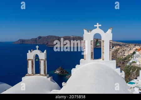 Blick auf Santorini Caldera mit Oia Stadt und berühmte Altstadt Weiße Turmglocken und blaue Kuppeln orthodoxer Kirchen Stockfoto