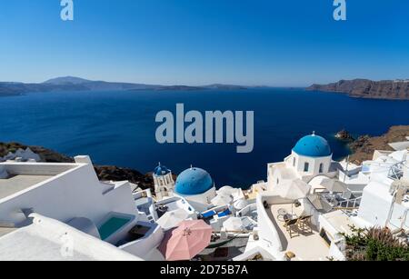 Wunderschöne Panoramasicht auf Santorini Caldera mit berühmten alten blauen Kuppeln der orthodoxen Kirchen Stockfoto