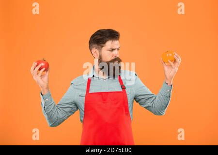 Tipps für das Wachstum am besten Tomate. Nutzen für die Gesundheit der Tomate. saftig und süß Gemüse. brutale Koch im Vorfeld. bärtiger Mann Chef mit Tomate. Tomaten sind ein äußerst nahrhafte pflanzliche Nahrung. Bio Diät. Stockfoto