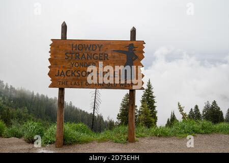 Jackson, Wyoming - 25. Juni 2020: Begrüßungsschild für Jackson Hole Area, Howdy Strangers - nebliger, bedecktem Tag auf Teton Pass Stockfoto