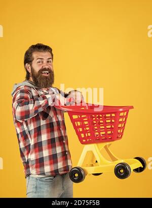 Mann in Einkaufszentrum. Kunde schieben Warenkorb. käufer im Supermarkt. Leere Spielzeug-Trolley. Wirklich beschäftigt Haushälterin. Perfekter Mann. Brauchen Einkaufsliste. Bärtiger Mann gehen mit leeren Warenkorb einkaufen. Stockfoto