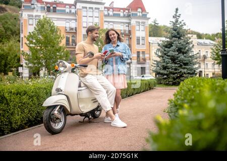 Mann und Frau mit Smartphones während einer Scooter-Reise Stockfoto