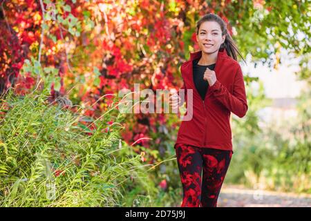 Gesunde aktive Lebensweise Laufen asiatische junge Frau Cardio-Training auf Stadtpark laufen Joggen im Freien im Herbst Blätter Stockfoto