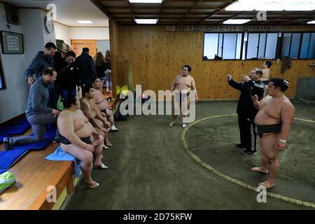 Besucher, die ihre Fotos mit Sumo-Ringer nach dem Besuch aufgenommen haben Eine Sumo-morgendliche Trainingseinheit in einem Stall.Koto City.Tokyo.Japan Stockfoto