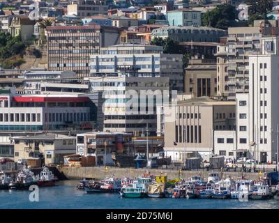 Valparaiso, Chile - 8. Dezember 2008: Gruppe von kleinen und Fischereifahrzeugen im Hafen mit städtischen Landschaft von Wohnungen und hohen Gebäuden mit Büro angedockt Stockfoto