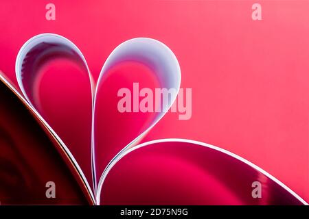 Herzförmige Papierseiten, heller abstrakter Hintergrund, Liebe und Valentinstag-Konzept Stockfoto