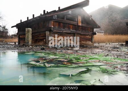 Heiße Quellen in Japan, die aus dem Boden kommen. Das Wasser ist grün von Schwefel und die Luft ist dampfig. Stockfoto