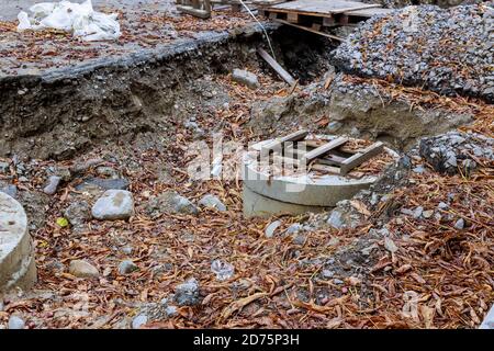 Die Reparaturarbeiten in der Stadt, die Reparatur der verlegenden Versorgungsbetriebe Beton gut für die Kommunikationen, die im Boden begraben sind Stockfoto