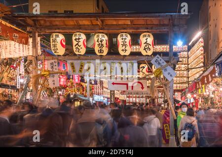 asakusa, japan - november 08 2019: Menge, die durch ein Tor der Tori-no-Ichi-Messe geht, die mit leuchtenden Laternen im Ootori-Schrein geschmückt ist, wo Händler b Stockfoto