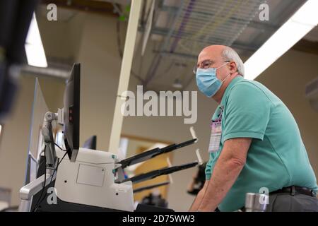 Renton, Washington, USA. Oktober 2020. Ein Wahlhelfer führt während eines Logik- und Genauigkeitstests der Tabulationsgeräte im King County Elections Headquarters Testabstimmungen durch einen Scanner durch. Quelle: Paul Christian Gordon/Alamy Live News Stockfoto