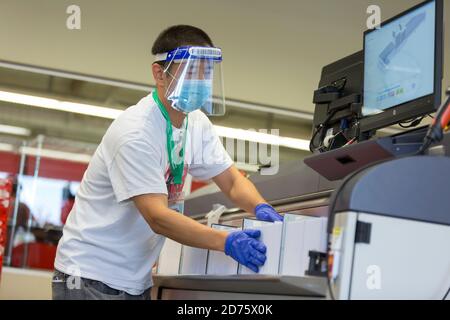 Renton, Washington, USA. Oktober 2020. Ein Wahlarbeiter lädt Stimmzettel in eine Sortiermaschine bei der King County Wahl Hauptquartier. Quelle: Paul Christian Gordon/Alamy Live News Stockfoto