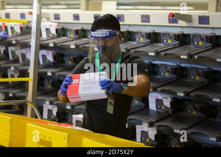 Renton, Washington, USA. Oktober 2020. Ein Wahlhelfer entfernt Stimmzettel von einer Sortiermaschine bei der King County Wahl Hauptquartier. Quelle: Paul Christian Gordon/Alamy Live News Stockfoto