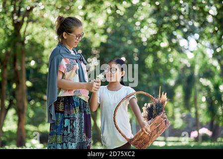 Eine Mutter schenkt ihrer Tochter weiße Blumen Stockfoto