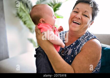 Großmutter auf dem Sofa mit Baby zu Hause Stockfoto