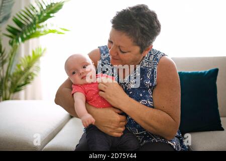Großmutter auf dem Sofa mit Baby zu Hause Stockfoto