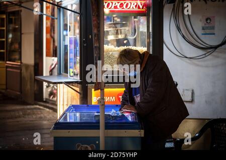 BELGRAD, SERBIEN - 10. OKTOBER 2020: Weibliche Senior Worker, Eisverkäufer, serviert Eis in den Straßen von Belgrad mit einem respiratorischen Gesicht m Stockfoto