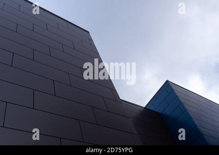 Beigefarbene und blaue Außenwände eines modernen Aluminium-Geschäftsgebäudes mit länglichen Metallverbundpaneelen. Stockfoto