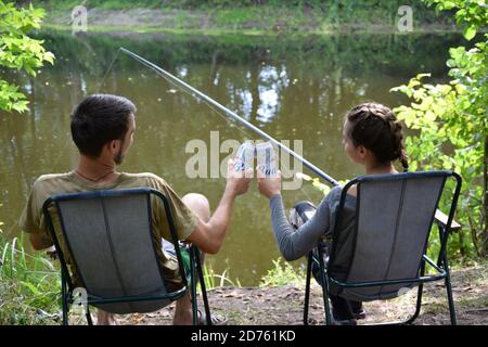 KHARKOV, UKRAINE - AUGUST 22 2020: Junge und Mädchen jubeln mit Budweiser Lager Alkohol Bier kann während des Fischens. Budweiser ist Marke von Anheuser-Busch in Stockfoto