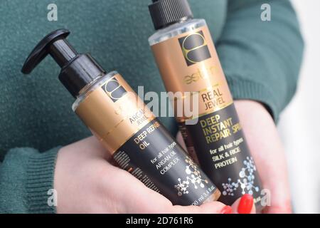 CHARKOW, UKRAINE - OKTOBER 16 2020: Junges Mädchen hält Estima-Produkte. Estima Argan Juwel tief Reparatur Öl und echte Juwel tief Instant Reparatur Spray Stockfoto