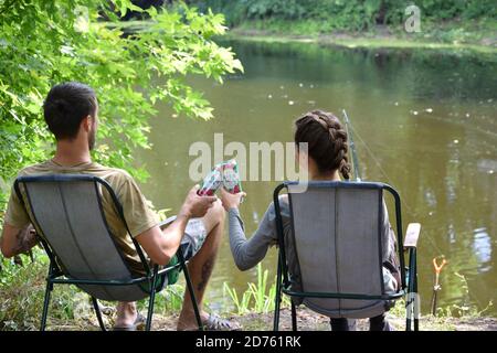 KHARKOV, UKRAINE - AUGUST 22 2020: Junge und Mädchen jubeln mit Budweiser Lager Alkohol Bier kann während des Fischens. Budweiser ist Marke von Anheuser-Busch in Stockfoto