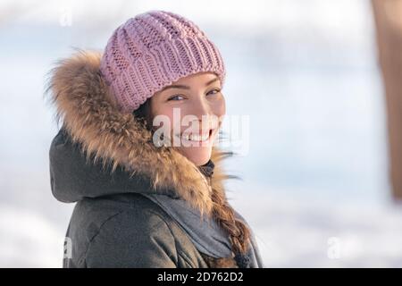 Winter Frau Porträt in kalten Outdoor-Natur. Asiatische Mädchen Modell tragen Wollmütze und Pelzjacke draußen im Winter Hintergrund, natürliche Schönheit Stockfoto