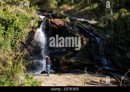 Weitaufnahme des Mato Limpo Wasserfalls mit seiner grünen Vegetation und klarem Wasser, das über die Felsformationen spritzt. Cunha, Sao Paulo - Brasilien. Stockfoto