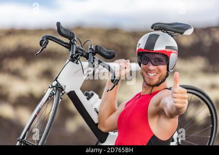 Triathlon Biken - männlichen Triathleten Radfahren Daumen nach oben Erfolg Handzeichen jubeln glücklich aufgeregt an der Kamera. Fit Mann Radfahrer auf Profi Stockfoto