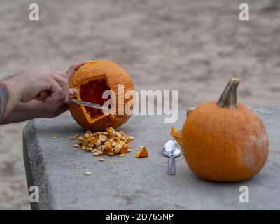 Mann mit einem Messer Schnitzerei einen Kürbis für ein Halloween Laterne Stockfoto