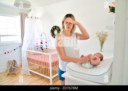 Eine Mutter, die die Wickelwindel im Kinderzimmer wechselt Stockfoto