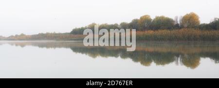 Schöne Reflexionen auf einem sehr ruhigen flachen Fluss bei Sonnenaufgang Stockfoto