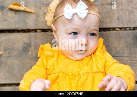 Draufsicht auf kleine niedliche Baby mit Ahorn Herbst Blätter Schließen Stockfoto