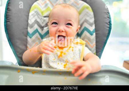 Happy Little cute Baby Mädchen mit Mash Essen überall Stockfoto