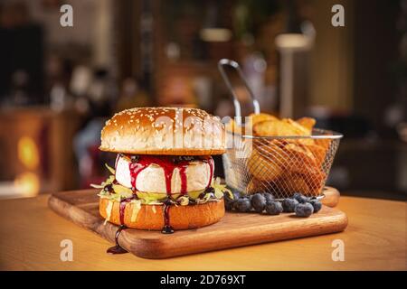 Vegetarischer Burger mit Camembert und Cranberry-Sauce serviert mit Pommes frites Stockfoto