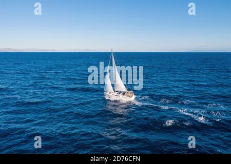 Segeln. Segelboot mit offenen weißen Segeln, blauem Himmel und Meer, windiger Tag. Urlaub Mediterranean Sea Griechenland im Sommer Stockfoto