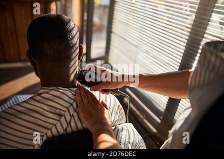 Afro-amerikanischer Mann bekommt Frisur im Friseurladen Stockfoto