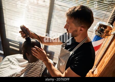 Afro-amerikanischer junger Mann bekommt Frisur im Friseurladen Stockfoto