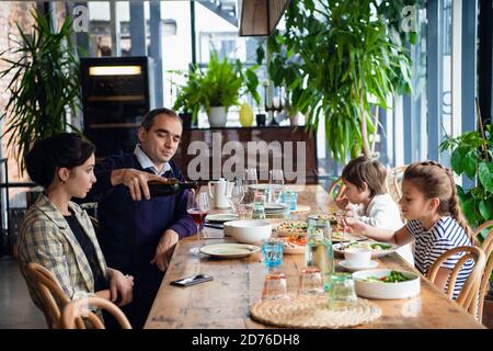 Eine vierköpfige Familie, die in einem Café zu Abend gegessen hat. Stockfoto