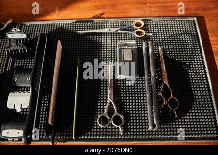 Friseurwerkzeuge auf schwarzer Gummimatte im Friseurladen Stockfoto
