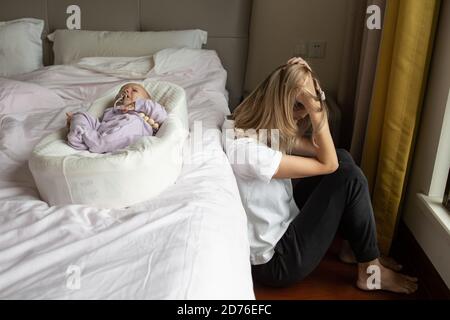 Müde Mutter leidet unter postnatalen Depressionen. Gesundheit Mutter Mutterschaft stressig. Bleiben Sie zu Hause während der Coronavirus covid-19 Pandemie Stockfoto