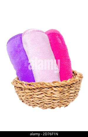 Korb mit drei bunten Frottee Handtücher oder Kosmetik für Körperpflege isoliert auf weißem Hintergrund. Bad-Accessoires und kosmetische Produkte. Makro. Stockfoto