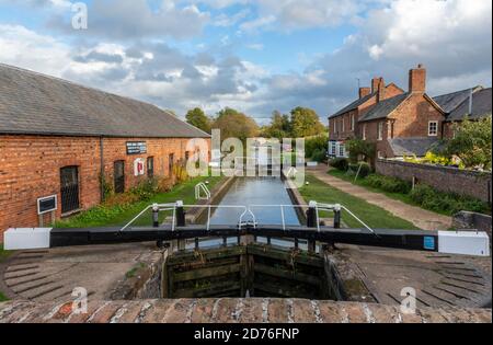 Untere Schleuse am Grand Union Canal bei Braunston in northamptonshire mit schmalen Schleusentoren und historischen Gebäuden auf der Kanalseite. Stockfoto