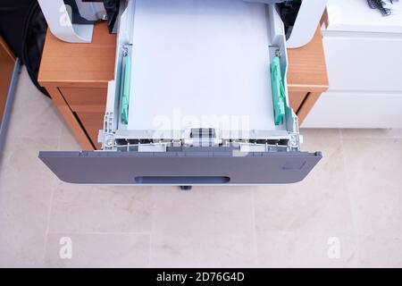 Öffnen Sie das Papierfach eines Bürodruckers mit Papier im Inneren, das zum Nachfüllen bereit ist. Stockfoto