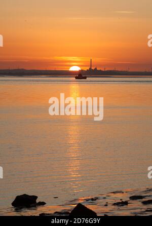 Ein dramatischer orangefarbener Sonnenuntergang über dem Humber bei Hessle In East Yorkshire Stockfoto