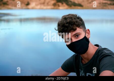 Junger Kaukasier mit schwarzer Maske Stockfoto