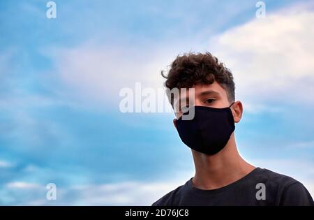 Junger Kaukasier mit schwarzer Maske Stockfoto