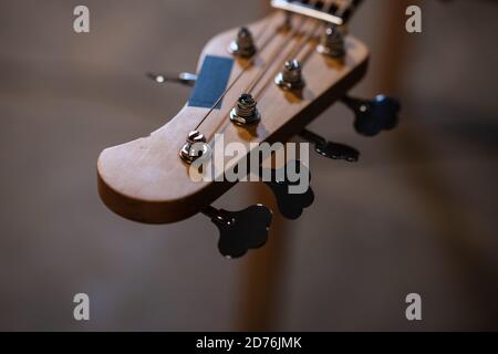 Stimmwirbel und Griffbrett Bass Gitarre Nahaufnahme auf der Hintergrund der Wohnung des Musikers mit Kopierraum Stockfoto